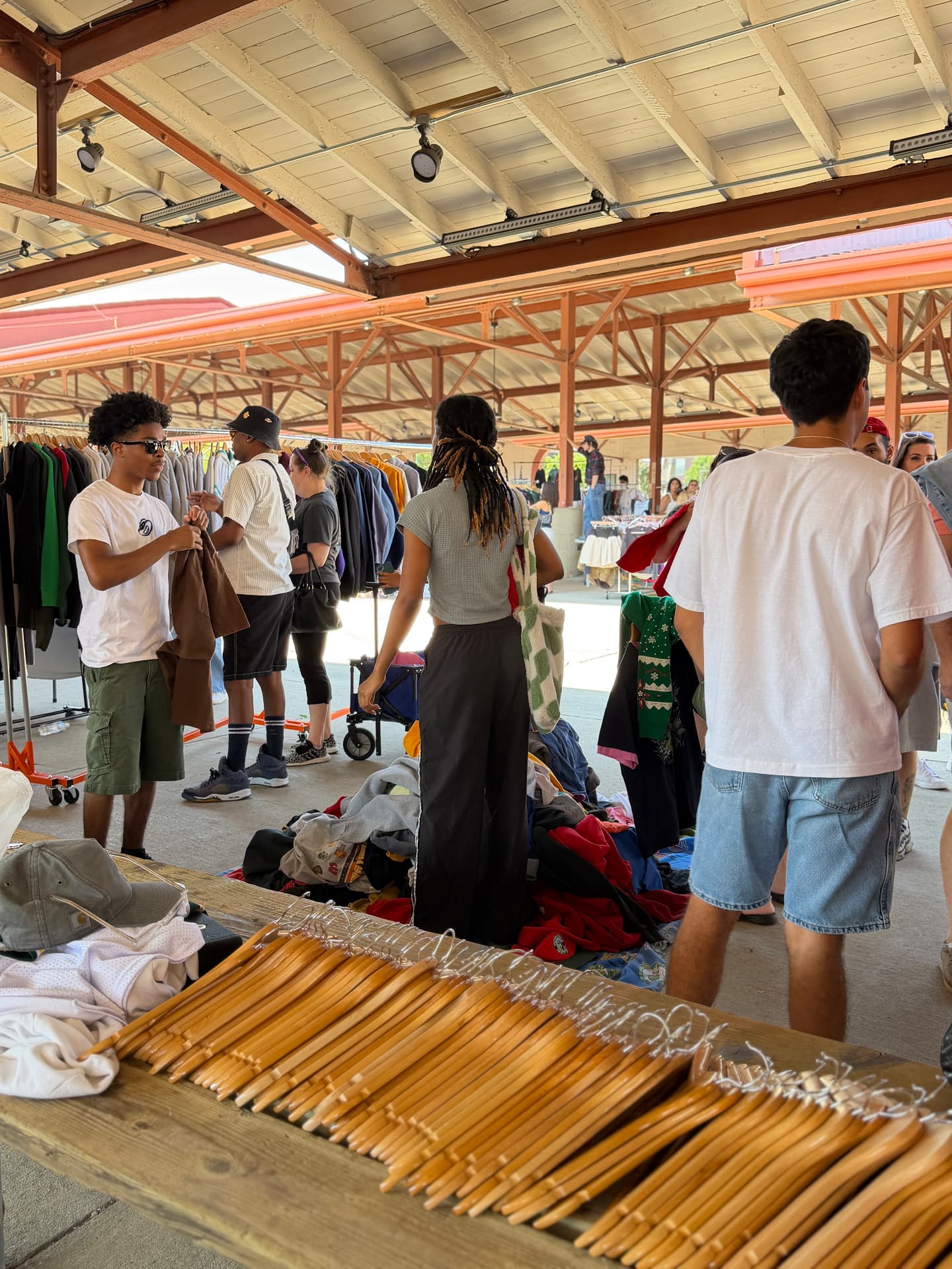 Crowd shopping vintage racks at an outdoor Milwaukee market