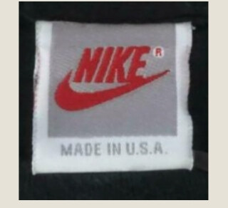 Vintage Nike gray tag with red Nike lettering inside a gray panel