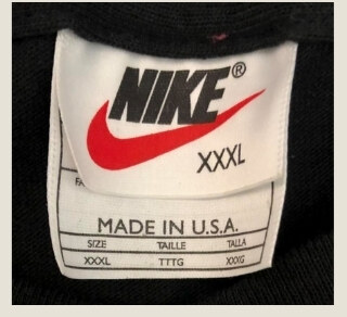 Vintage Nike white tag with black lettering and a red swoosh